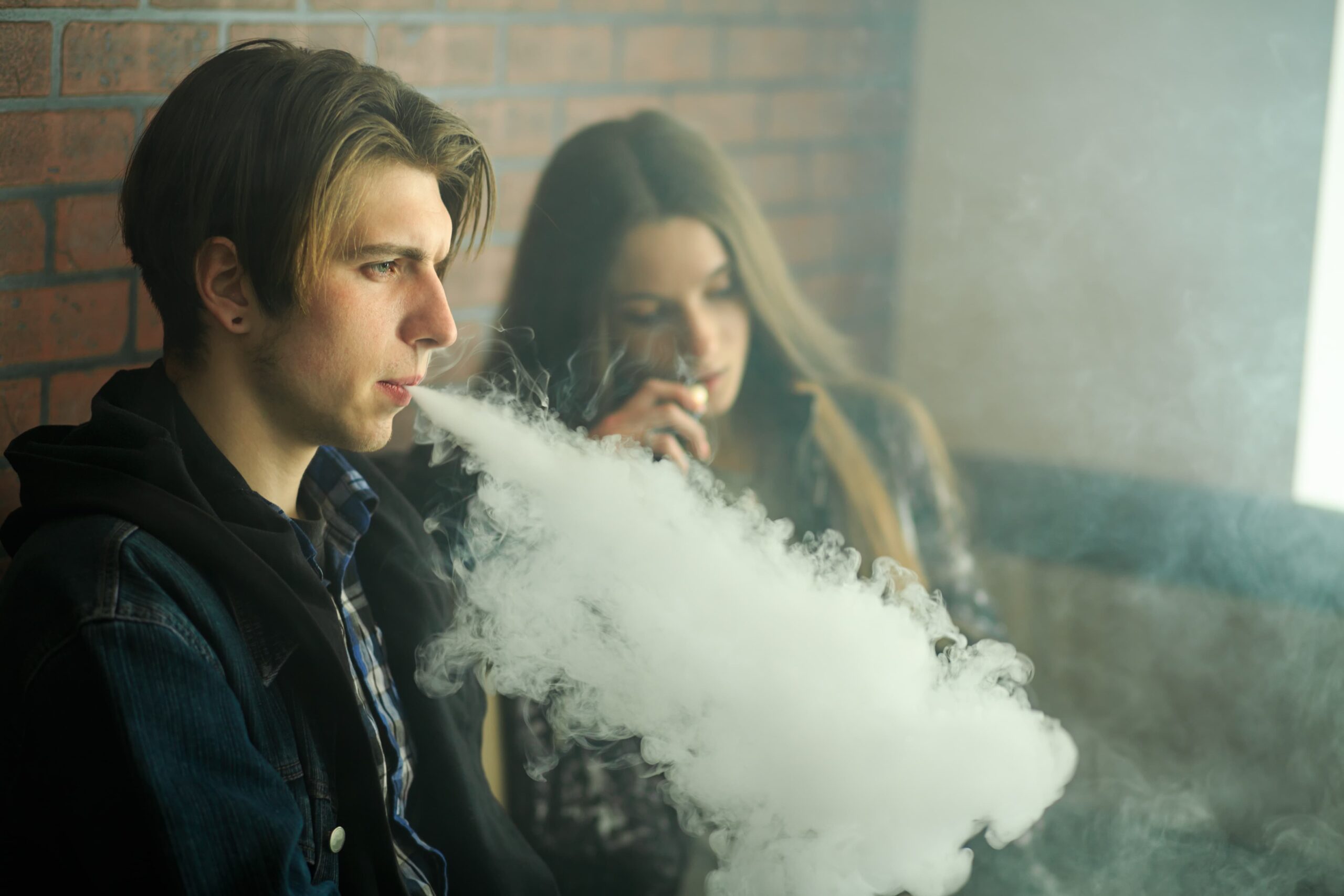 Two young people vaping